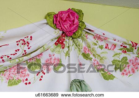 WINDOW TREATMENTS: hidden tatters on a vintage linen tablecloth draped into a curtain, embellished with ribbon rose at the top View Large Photo Image Stock Photo - WINDOW TREATMENTS: hidden tatters on a vintage linen tablecloth draped into a curtain, embellished with ribbon rose at the top. Fotosearch