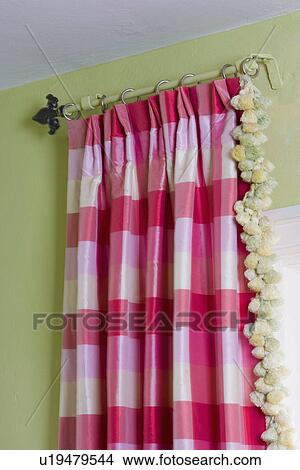 Picture - WINDOW TREATMENTS: pink and white buffalo check, with pom pom fringe detail, fleur de lys finial on antique rod, lime green wall. Fotosearch