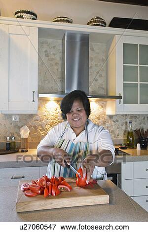 Woman slicing tomatoes in kitchen, Mykonos, Greece View Large Photo Image Stock Photo - Woman slicing tomatoes in kitchen, Mykonos, Greece. Fotosearch