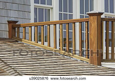 Stock Photograph - Wooden balcony railing and shingled roof. Fotosearch
