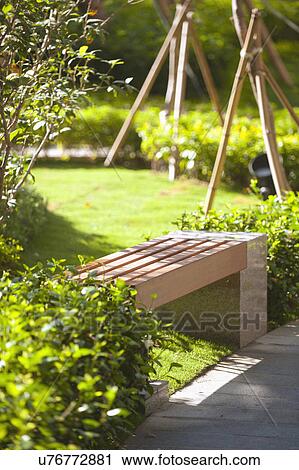 Wooden bench in garden View Large Photo Image Stock Image - Wooden bench in garden. Fotosearch