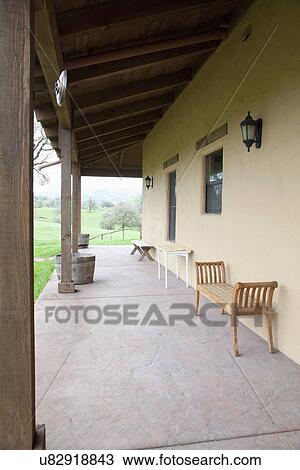 Stock Image - Wooden bench on veranda alongside house; Porterville; California; USA. Fotosearch