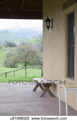 Stock Photograph - Wooden bench on veranda alongside house; Porterville; California; USA. Fotosearch