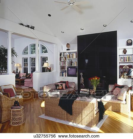 Stock Photograph - Woven furniture in traditional living room with high ceilings. Fotosearch