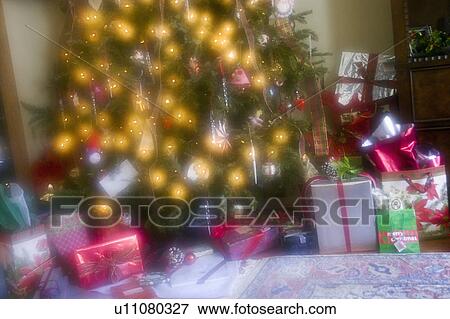Stock Photo - Wrapped gift boxes with decorated Christmas tree. Fotosearch