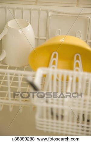 Stock Photo - Yellow bowl in dish drying rack; Carpinteria; California; USA. Fotosearch