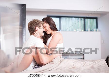 Affectionate young couple on bed View Large Photo Image Picture - Affectionate young couple on bed. Fotosearch