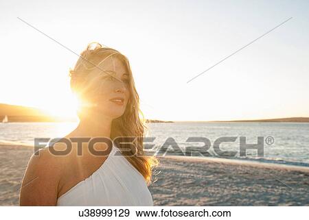 Stock Photo - Blond woman on beach at dusk, Cape Town, South Africa. Fotosearch