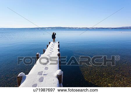 Boy standing on snow covered pier, Lake Starnberg, Bavaria, Germany View Large Photo Image Stock Photo - Boy standing on snow covered pier, Lake Starnberg, Bavaria, Germany. Fotosearch