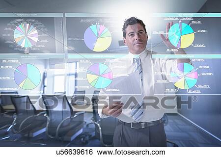 Businessman looking at pie charts on interactive screen View Large Photo Image Stock Photograph - Businessman looking at pie charts on interactive screen. Fotosearch