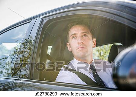 Businessman looking up from car window View Large Photo Image Stock Photo - Businessman looking up from car window. Fotosearch