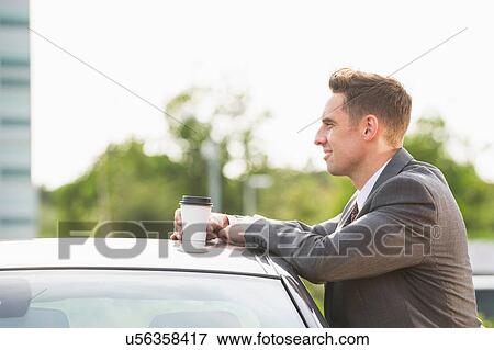Businessman taking a break whilst leaning against car View Large Photo Image Stock Photo - Businessman taking a break whilst leaning against car. Fotosearch
