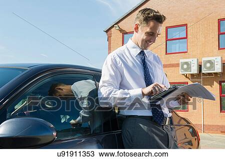Businessman using computer tablet outside office View Large Photo Image Stock Image - Businessman using computer tablet outside office. Fotosearch