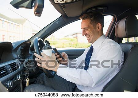 Businessman with coffee and mobile in his car View Large Photo Image Stock Photo - Businessman with coffee and mobile in his car. Fotosearch