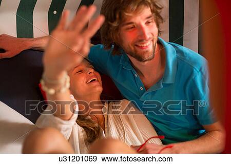 Stock Photo - Carefree young couple lounging in bar. Fotosearch