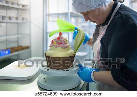 Chocolatier icing giant size cup cake View Large Photo Image Stock Photo - Chocolatier icing giant size cup cake. Fotosearch