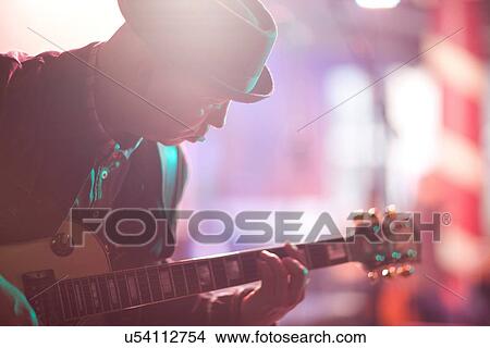 Picture - Close up mature man playing guitar on stage. Fotosearch