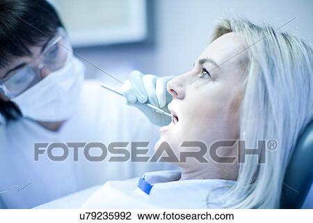 Stock Image - Close up of dentist checking patients teeth. Fotosearch