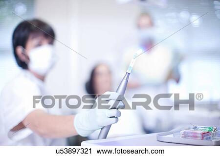 Close up of dentists hand holding ultraviolet light View Large Photo Image Stock Image - Close up of dentists hand holding ultraviolet light. Fotosearch