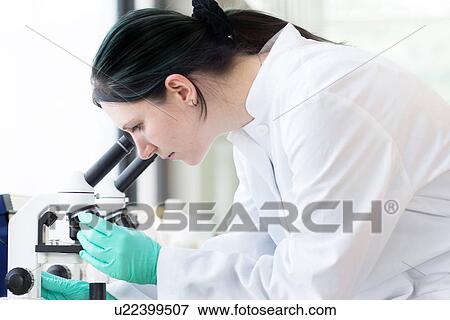 Close up of female scientist examining at test tube View Large Photo Image Stock Photo - Close up of female scientist examining at test tube. Fotosearch