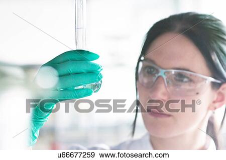 Close up of female scientist examining at test tube View Large Photo Image Stock Photo - Close up of female scientist examining at test tube. Fotosearch