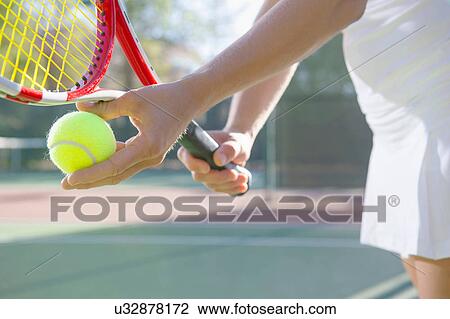 Stock Image - Close up of female tennis player preparing to serve. Fotosearch