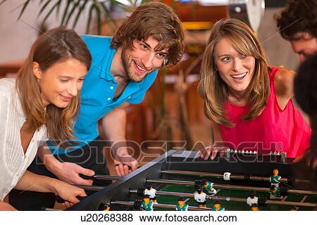 Close up of friends having fun playing table football View Large Photo Image Stock Photo - Close up of friends having fun playing table football. Fotosearch