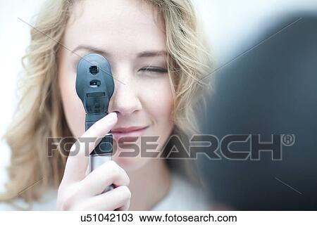Close up of optician looking through ophthalmoscope View Large Photo Image Stock Image - Close up of optician looking through ophthalmoscope. Fotosearch