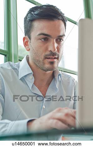 Close up of young male office worker using laptop View Large Photo Image Stock Image - Close up of young male office worker using laptop. Fotosearch