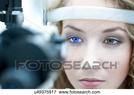 Stock Photo - Close up of young woman having eye examination. Fotosearch