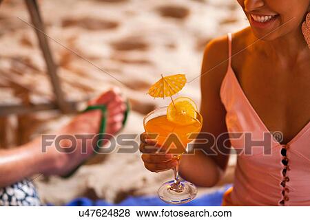 Close up of young woman holding cocktail View Large Photo Image Stock Photo - Close up of young woman holding cocktail. Fotosearch