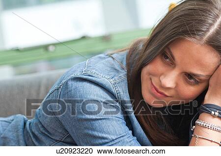 Close up of young woman lounging on sofa View Large Photo Image Stock Image - Close up of young woman lounging on sofa. Fotosearch