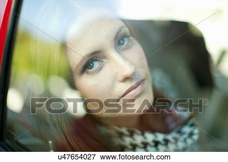 Close up of young woman staring out of car window View Large Photo Image Stock Photo - Close up of young woman staring out of car window. Fotosearch