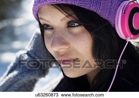 Close up portrait of young female listening to headphones View Large Photo Image Stock Image - Close up portrait of young female listening to headphones. Fotosearch