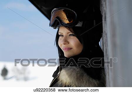 Stock Photo - Close up portrait of young female wearing ski goggles. Fotosearch