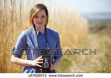 Close up portrait of young woman holding camera View Large Photo Image Stock Photography - Close up portrait of young woman holding camera. Fotosearch