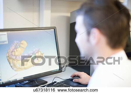 Stock Photograph - Dental technician looking at denture on screen. Fotosearch
