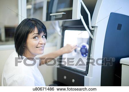 Stock Photograph - Dental technician using equipment to produce denture. Fotosearch