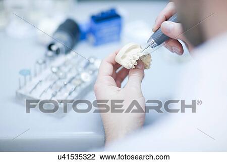 Stock Image - Dental technician working on denture. Fotosearch