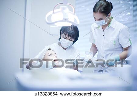 Dentist and nurse treating patient View Large Photo Image Picture - Dentist and nurse treating patient. Fotosearch