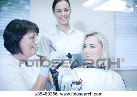 Dentist preparing to treat patient View Large Photo Image Stock Photograph - Dentist preparing to treat patient. Fotosearch