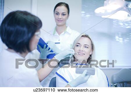 Stock Image - Dentist testing veneers on patient. Fotosearch