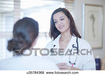 Stock Photo - Doctor and nurse chatting. Fotosearch
