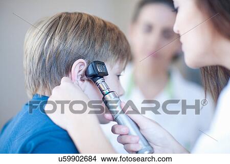 Picture - Doctor checking boys ear. Fotosearch