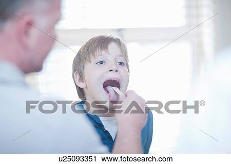 Doctor checking boys throat View Large Photo Image Stock Image - Doctor checking boys throat. Fotosearch