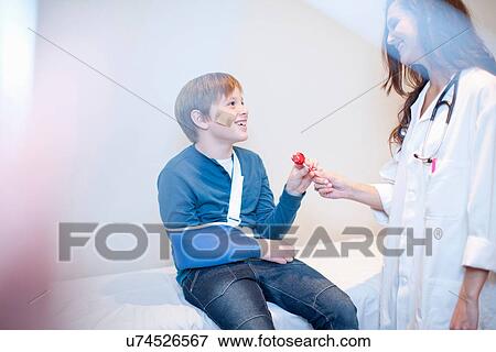 Stock Photo - Doctor giving young boy a lollipop. Fotosearch