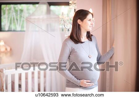 Expectant mother looking out of window View Large Photo Image Stock Image - Expectant mother looking out of window. Fotosearch