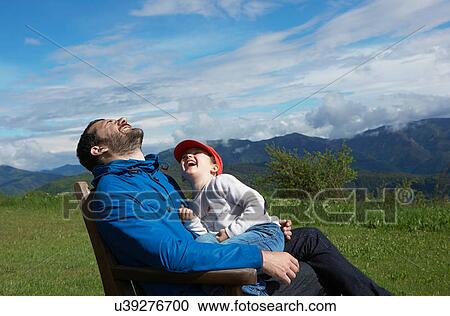 Father and daughter sitting on chair outdoors laughing View Large Photo Image Stock Image - Father and daughter sitting on chair outdoors laughing. Fotosearch