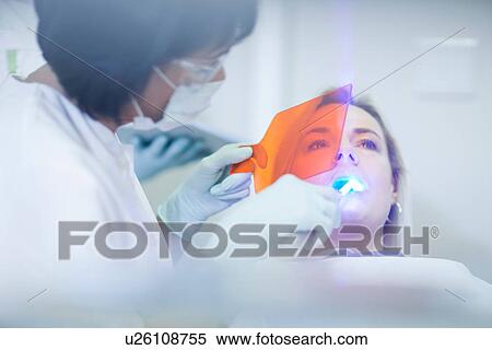 Female dentist applying ultraviolet light to patients teeth View Large Photo Image Stock Photography - Female dentist applying ultraviolet light to patients teeth. Fotosearch