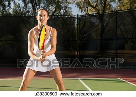 Stock Image - Female tennis player awaiting serve. Fotosearch